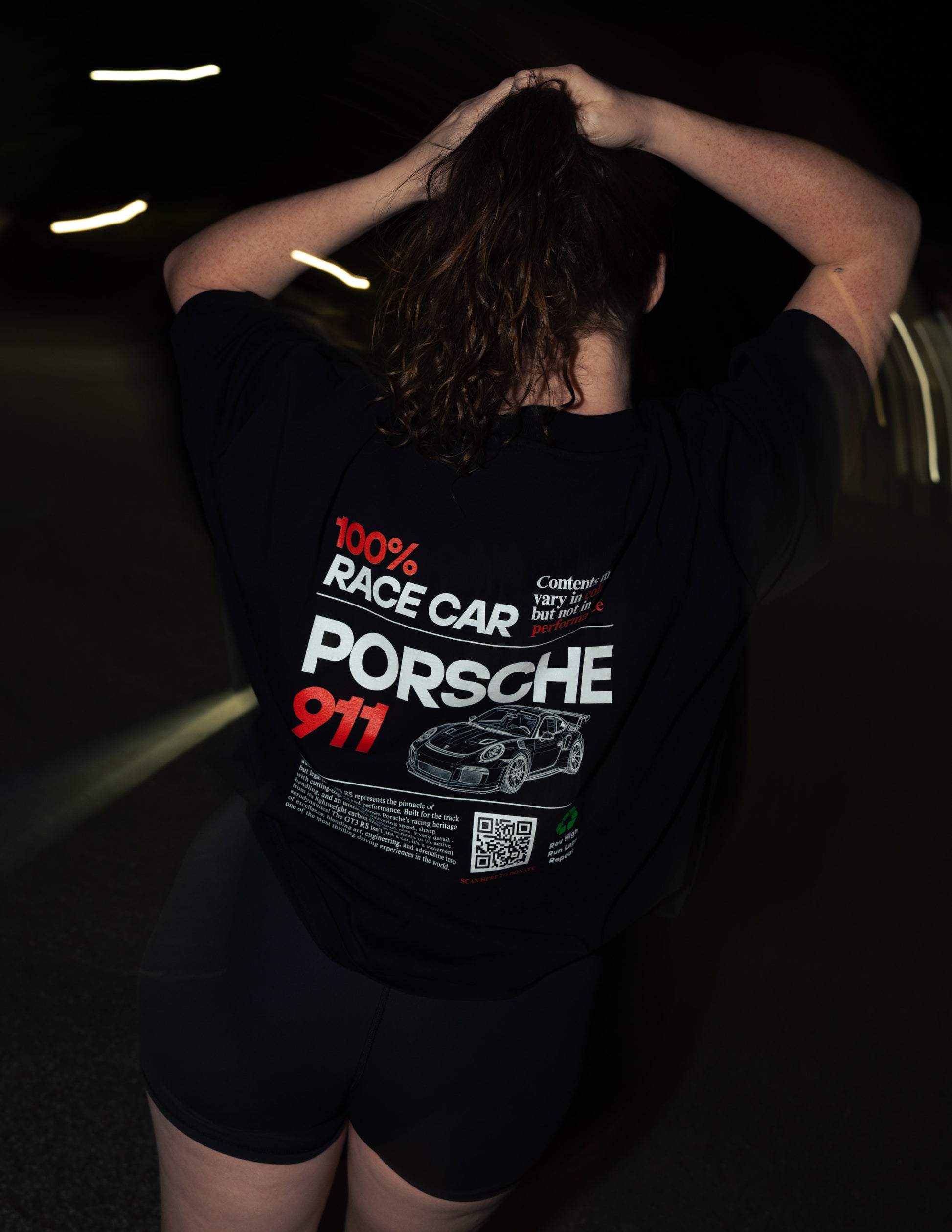 Person wearing a black Porsche t-shirt with '100% Race Car' text and a Porsche 911 logo.